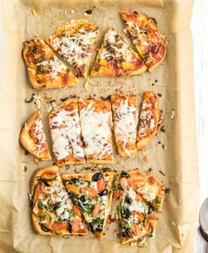 3 kinds of flatbread pizza baked and sliced on a baking sheet