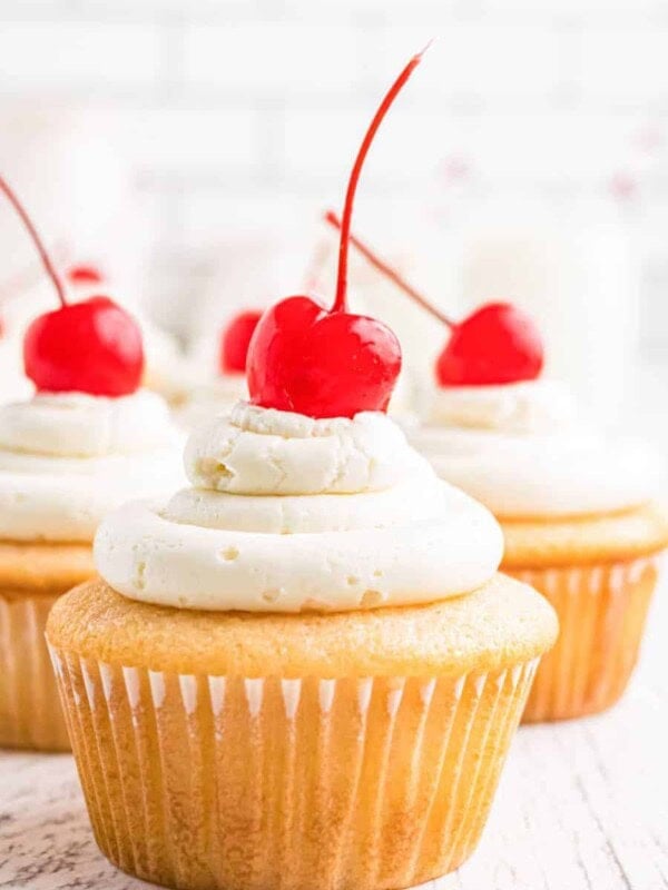 cluster of close up cherry chip cupcakes with maraschino cherries on top of each on