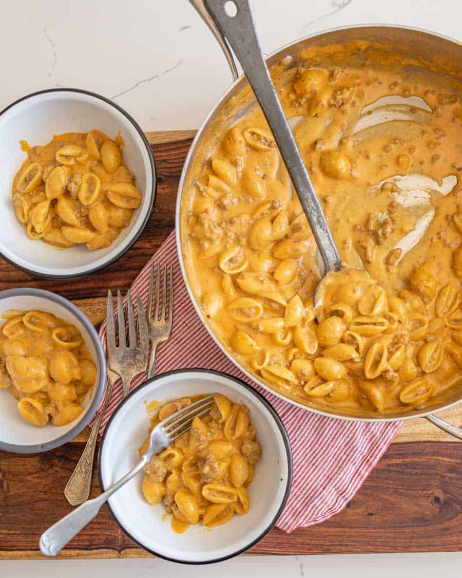 hamburger helper being served into three white bowls