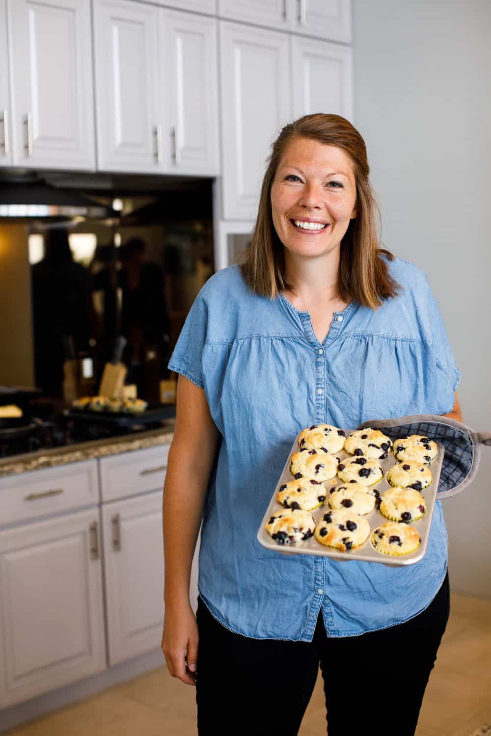 woman holding pan of muffins