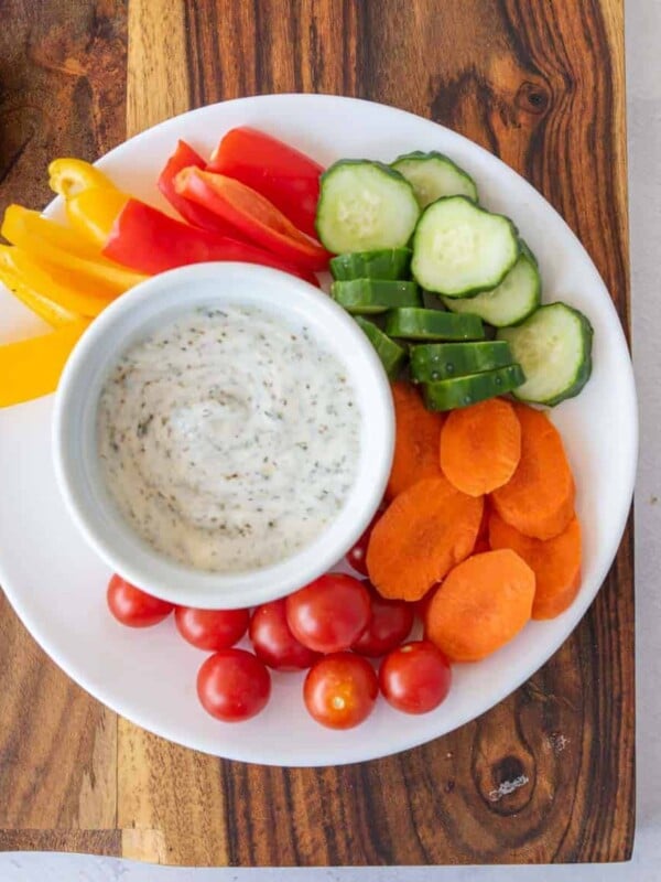plate of colorful veggies with dip in a bowl