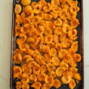 halved apricots on baking sheet.