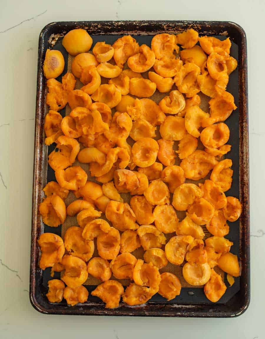 halved apricots on baking sheet