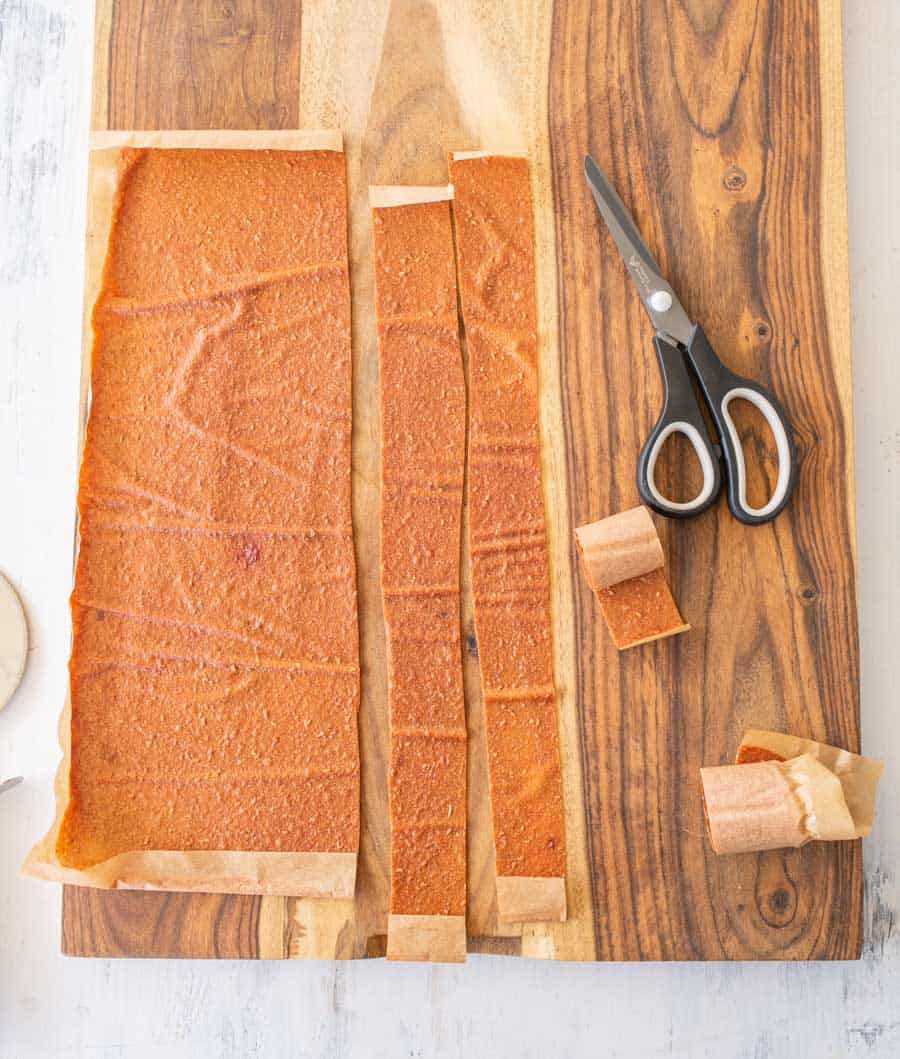 cutting finished fruit leather into strips with scissors