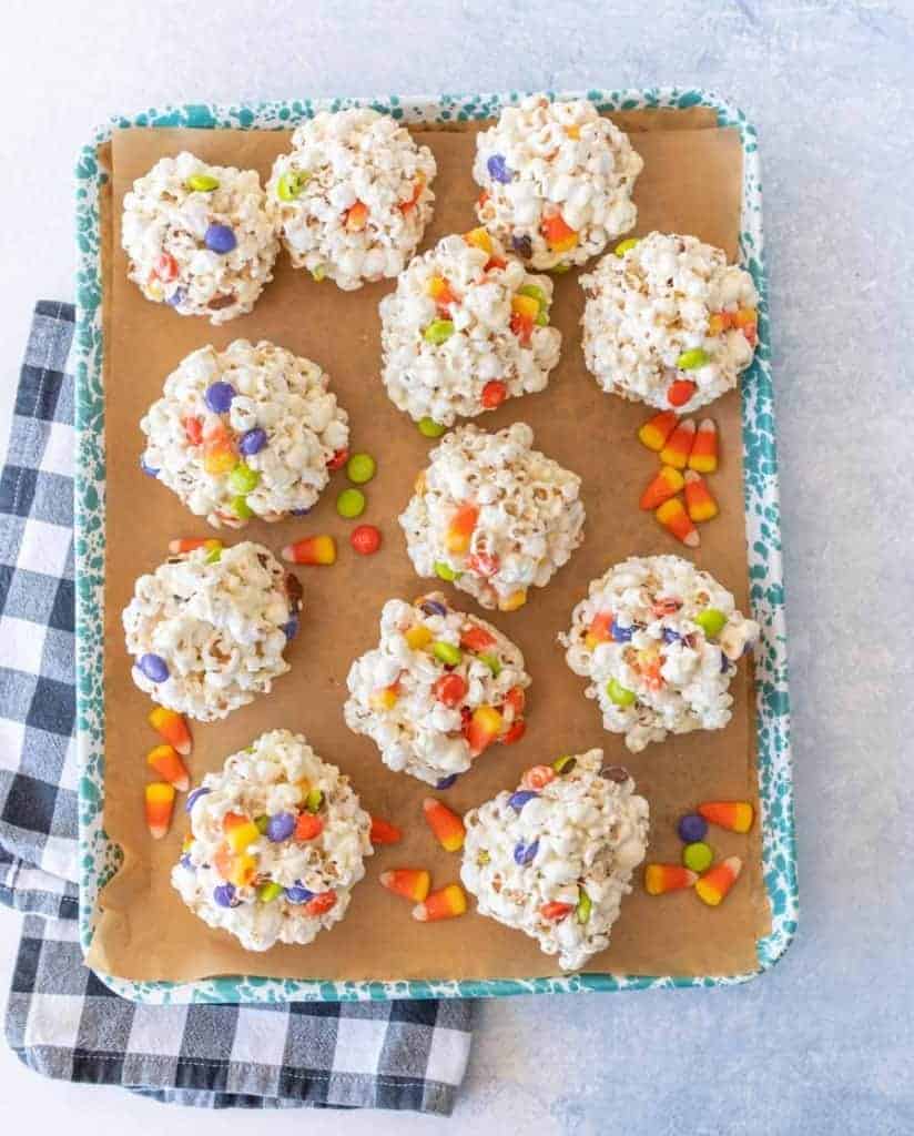 halloween popcorn balls with candy corn on enamel baking sheet