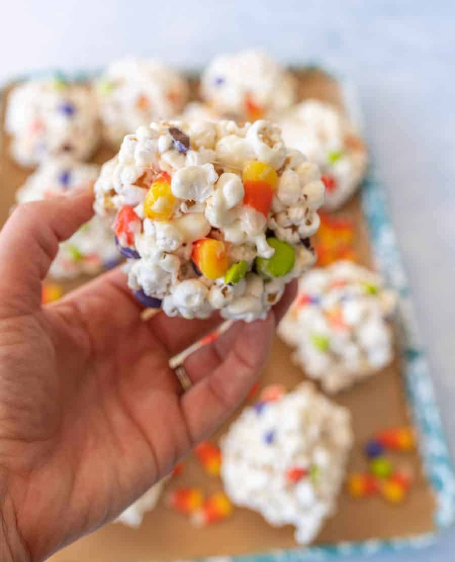 halloween popcorn balls with candy corn in hand