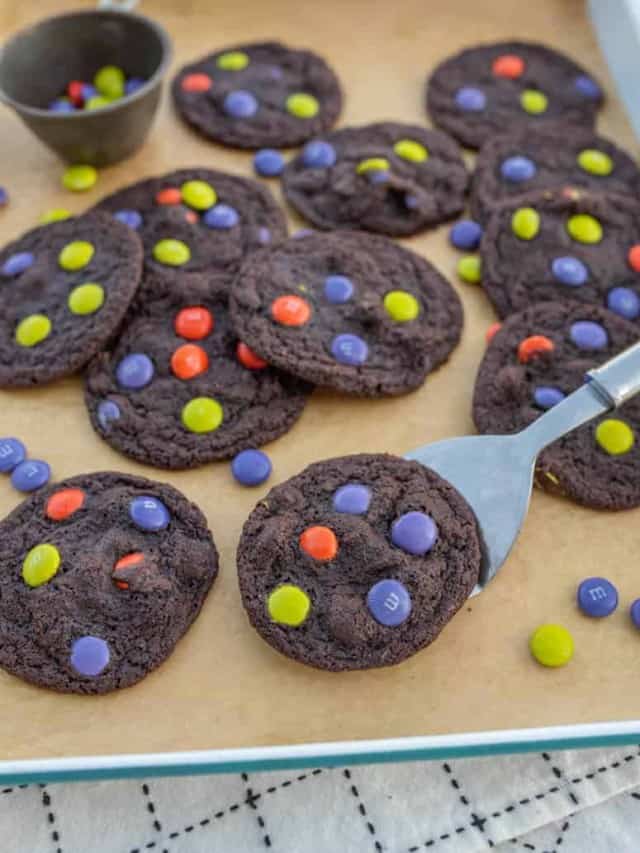 baking sheet filled with dark chocolate halloween M&M cookies.