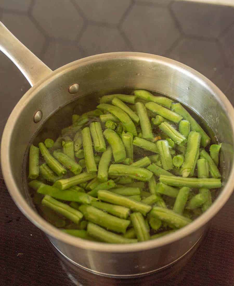 green beans in water in pot on cooktop