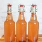 thee wire lid carafe bottles of orange second ferment kombucha with oranges and cherries in the bottom for how to make kombucha.