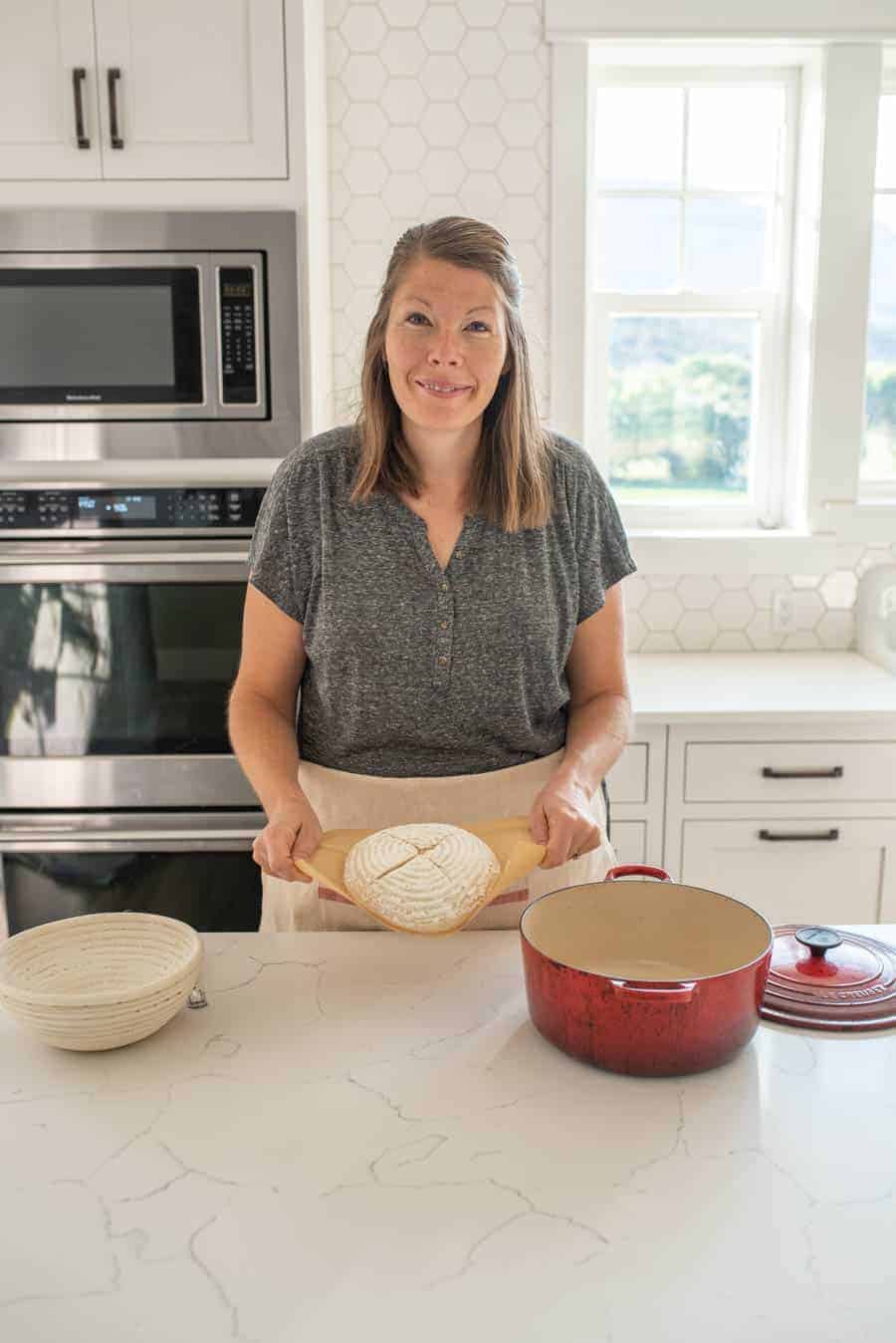 woman holding loaf of sourdough bread