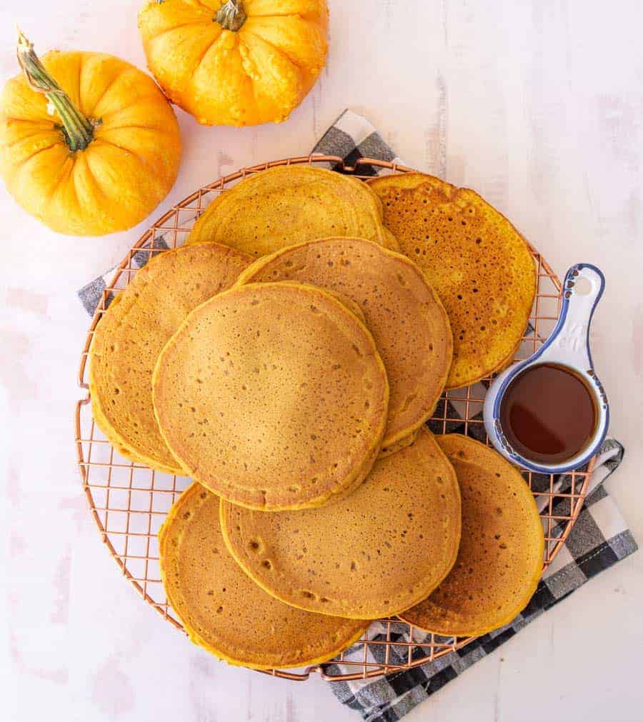 pumpkin pancakes resting on a copper round cooling rack