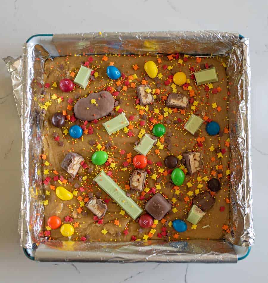 unbaked cookies bars with assorted candy on top