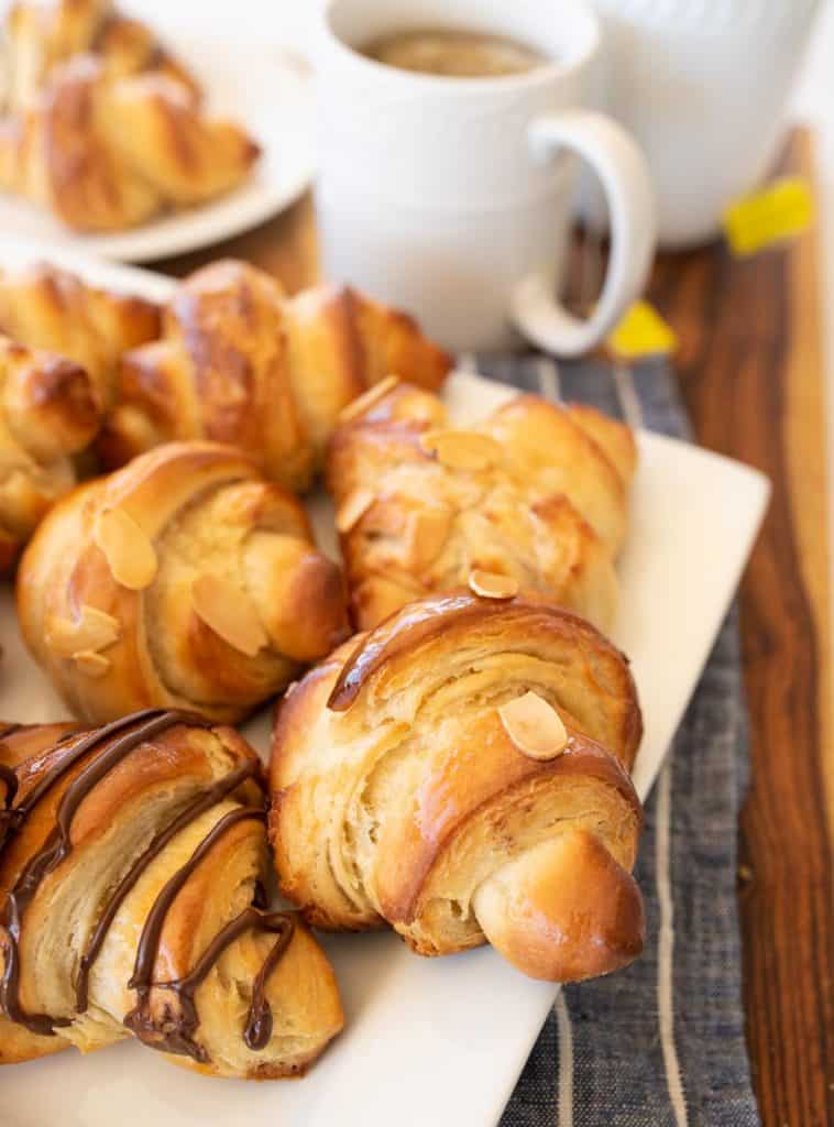 three kinds of croissants on a white plate with tea close up