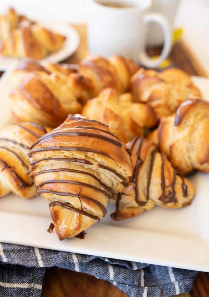 three kinds of croissants on a white plate with tea