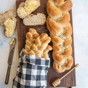 4 loaves of bread bread on a dark wood cutting board
