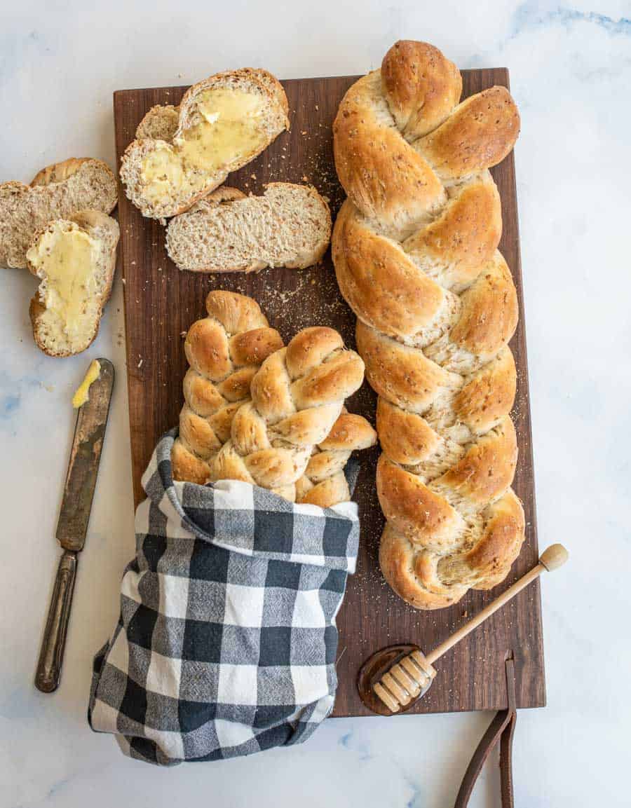 4 loaves of bread bread on a dark wood cutting board