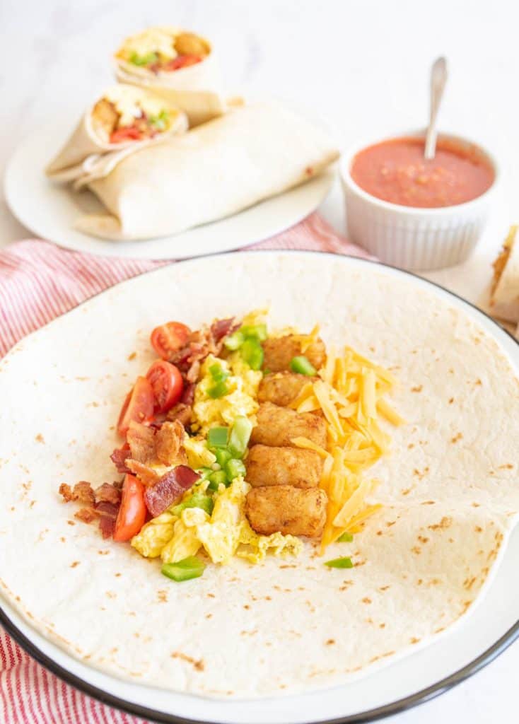 plate of breakfast burrito ingredients on a tortilla