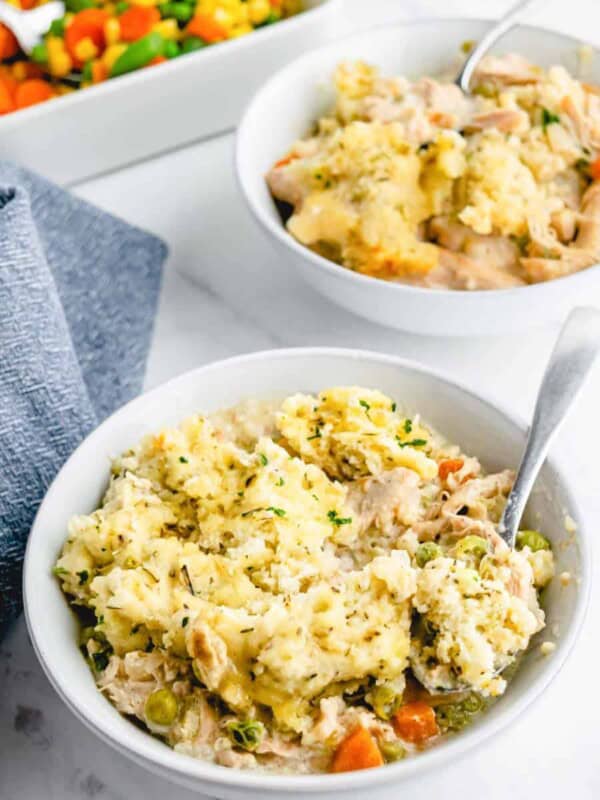 two bowls of chicken stew and a spoon