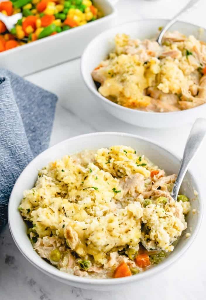 two bowls of chicken stew and a spoon