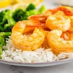 zoom dish with cooked garlic shrimp over white rice and broccoli to the side