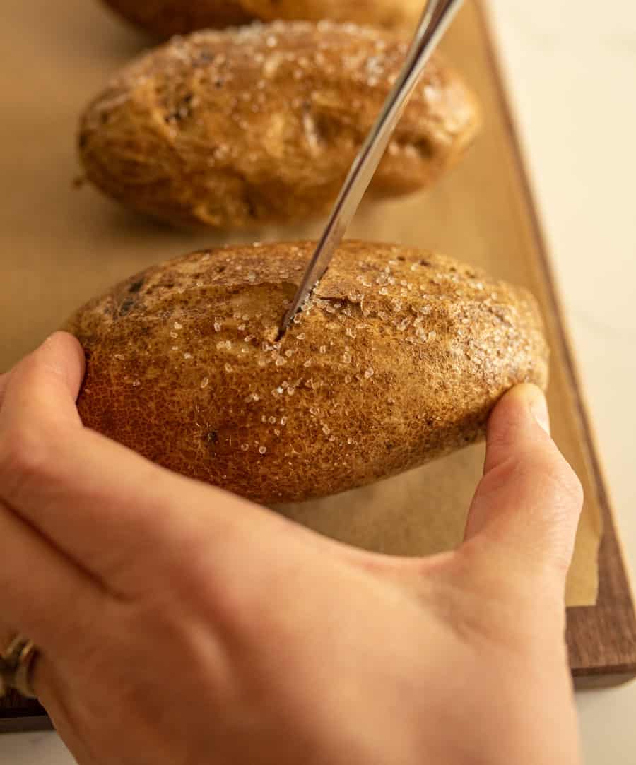 hand holding potato that is being cut