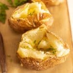 close up view of baked potato with other baked potatoes in the background