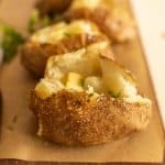 close up view of baked potato with baked potatoes in the background