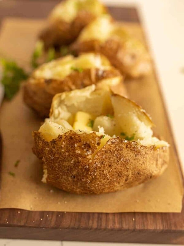 close up view of baked potato with baked potatoes in the background