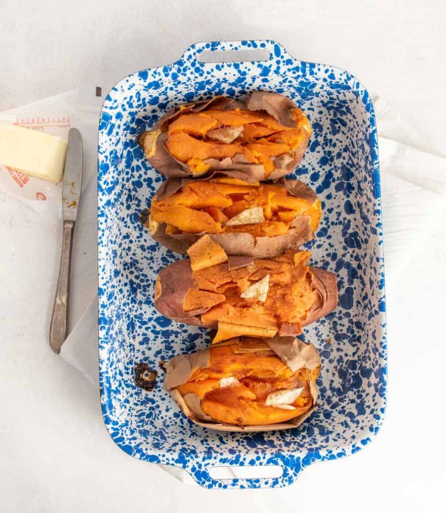 top view of baked sweet potatoes in a white and blue speckled baking dish