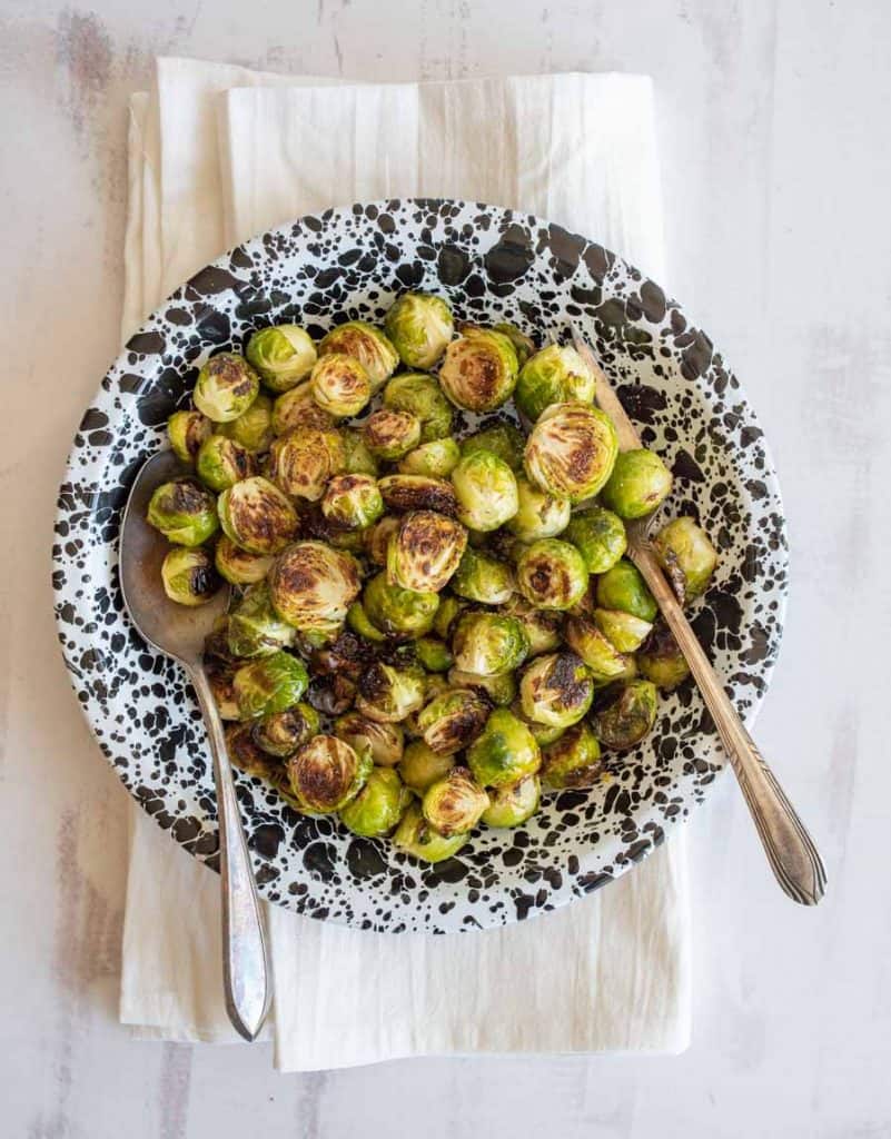 top view of roasted Brussel sprouts in bowl with serving spoon