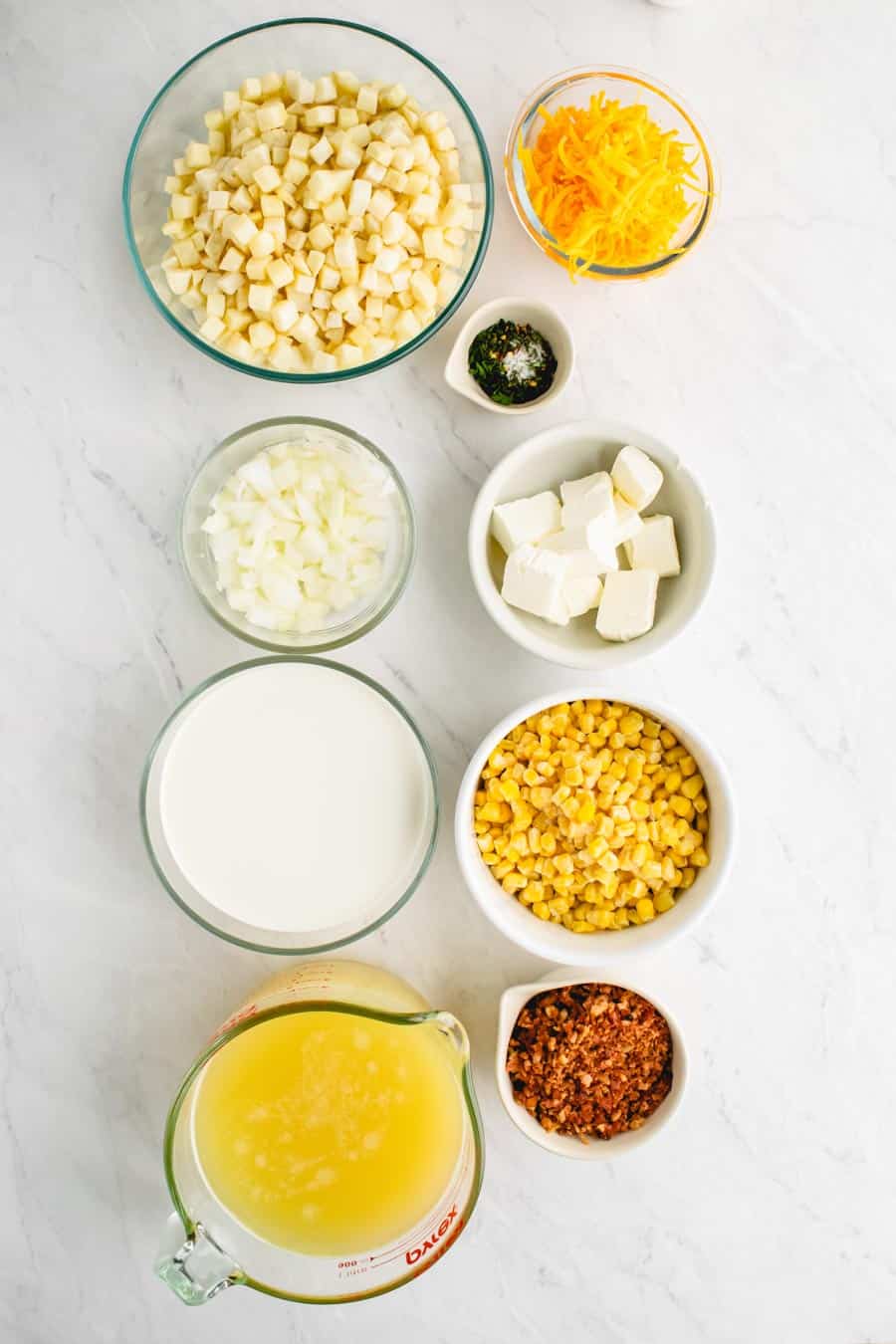 A top view of the ingredients for potato soup in their own individual bowls.