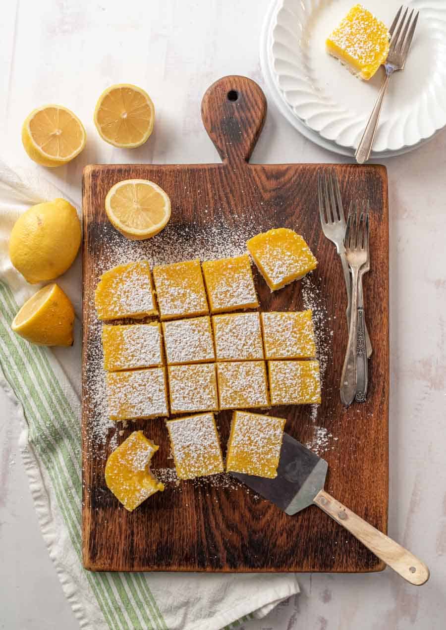 Top view of cut lemon bars on a wood cutting board.