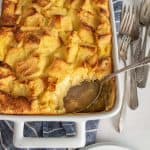 Missing scoop of French toast breakfast casserole out of a dish with a spoon in it