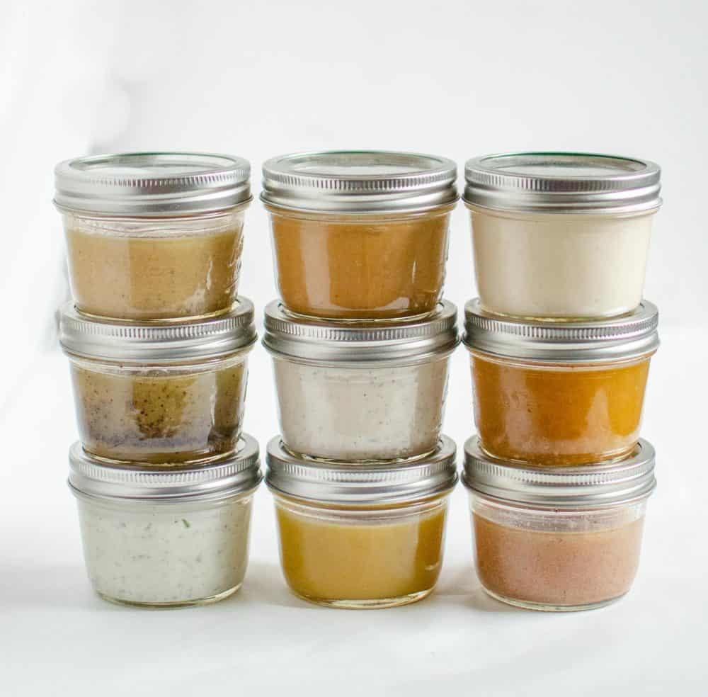 Jars of different salad dressings stacked on top of each other