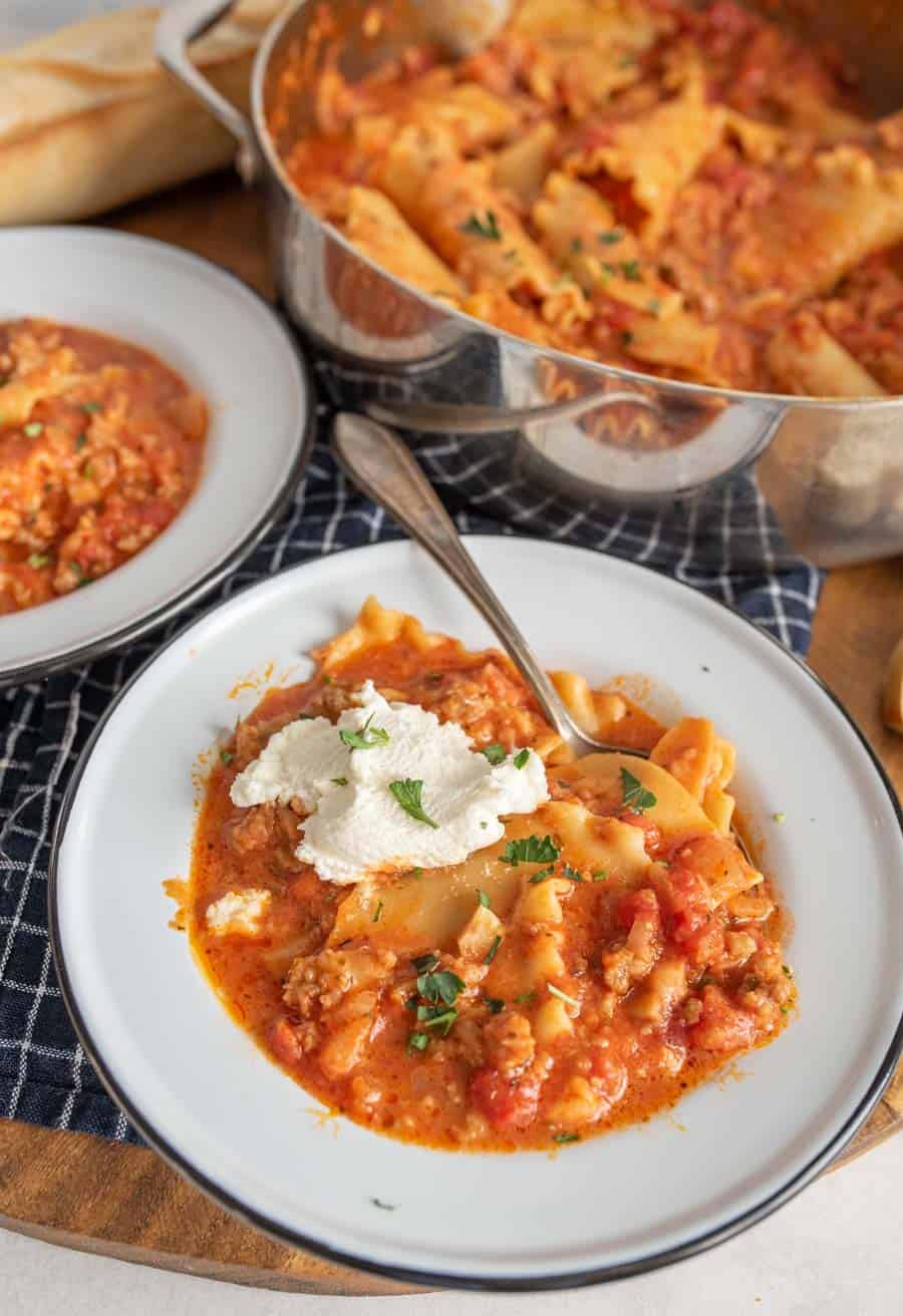 lasagna soup with a dollop of ricotta on top and parsley