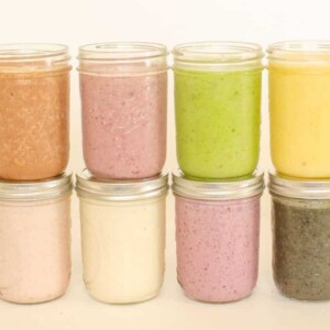 Glass jars filled with smoothies stacked on top of each other.