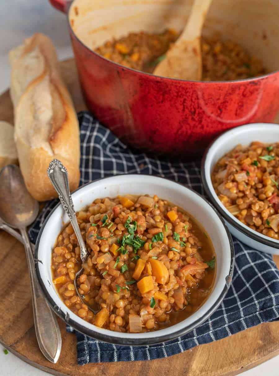 vegetarian lentil soup topped with parsley in a white bowl