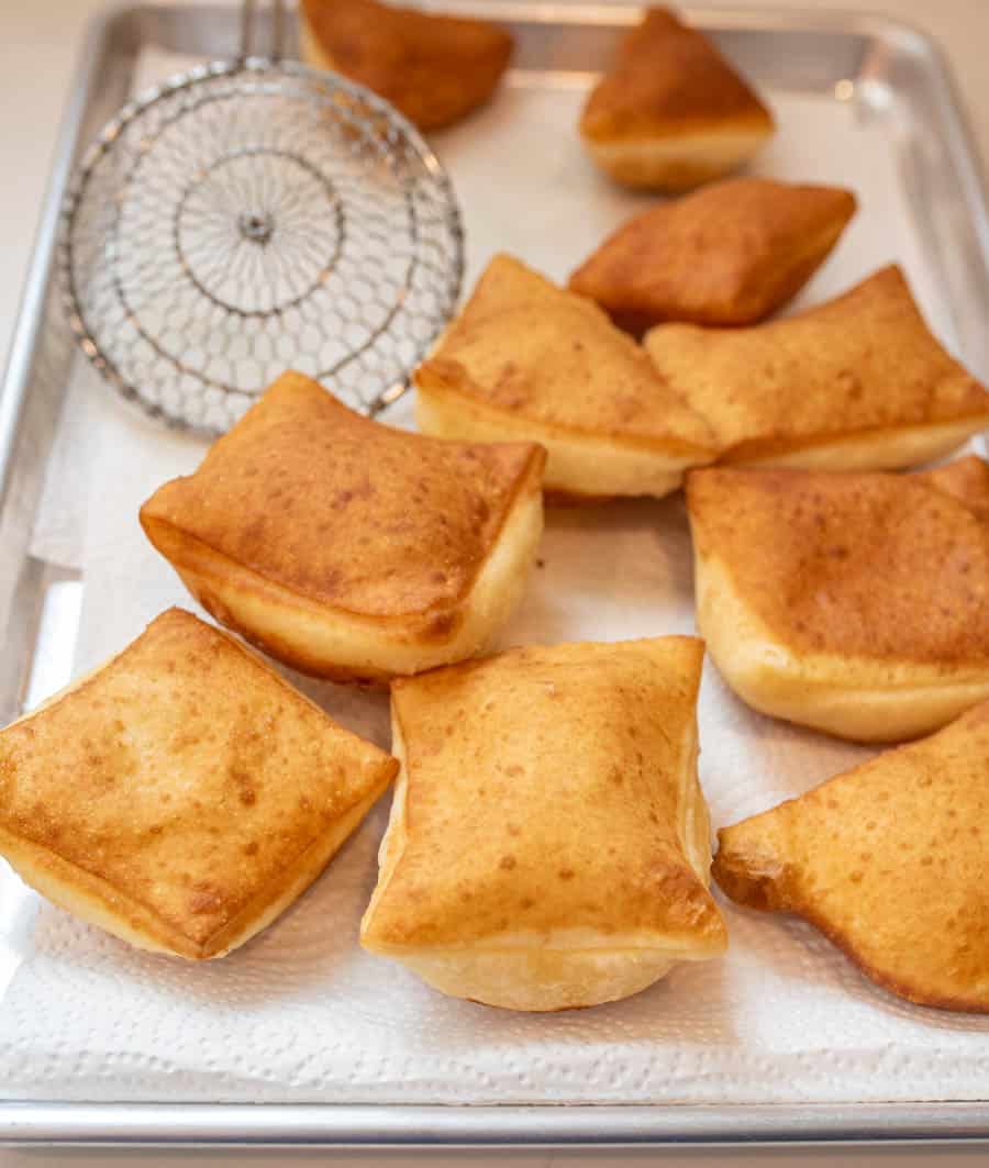 picture of beignets on a paper towel lined baking sheet