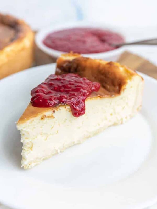 slice of cheesecake topped with raspberry sauce on a plate