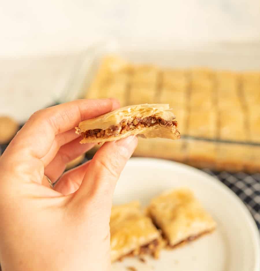 close up of a hand holding a piece of baklava