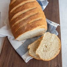 top view of Italian bread on a cutting board with a few slices cut off of it