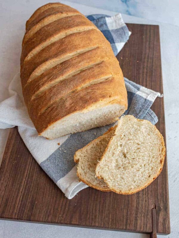 top view of Italian bread on a cutting board with a few slices cut off of it