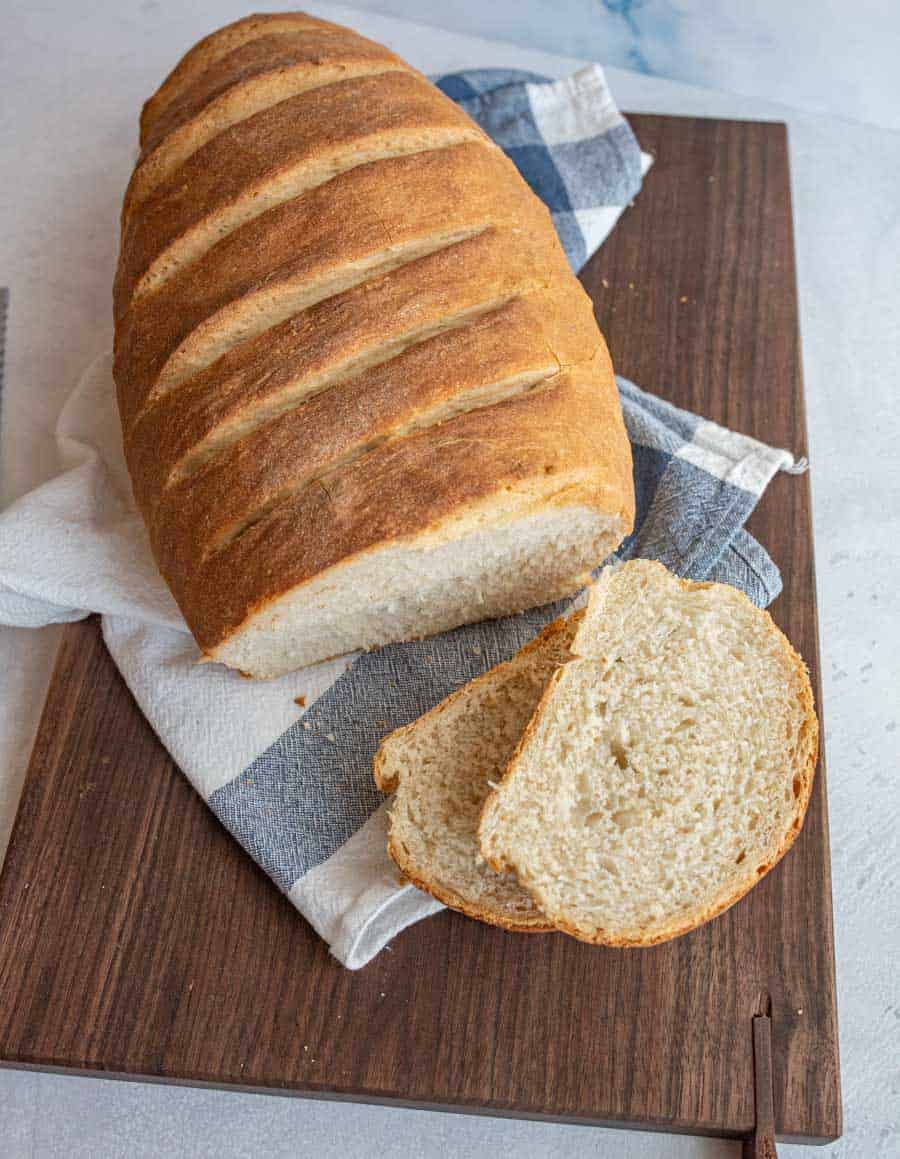 top view of Italian bread on a cutting board with a few slices cut off of it