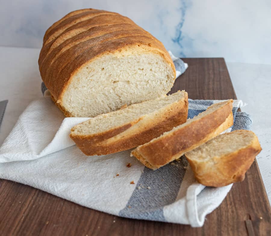 Italian bread with a few slices cut from it on a cutting board