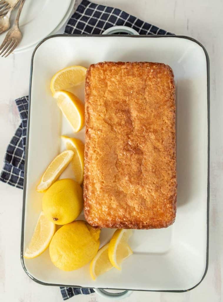 top view of lemon pound cake sliced up on a tray with lemons next to it