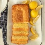 top view of lemon pound cake sliced up on a tray with lemons next to it