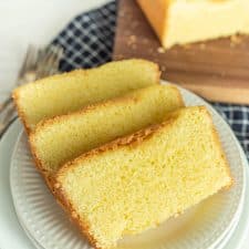 slices of pound cake on a plate with pound cake on a cutting board in the background