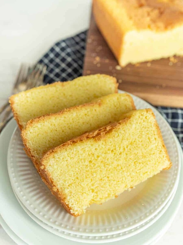 slices of pound cake on a plate with pound cake on a cutting board in the background