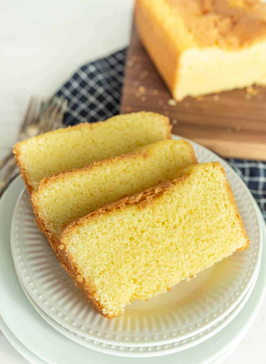 slices of pound cake on a plate with pound cake on a cutting board in the background