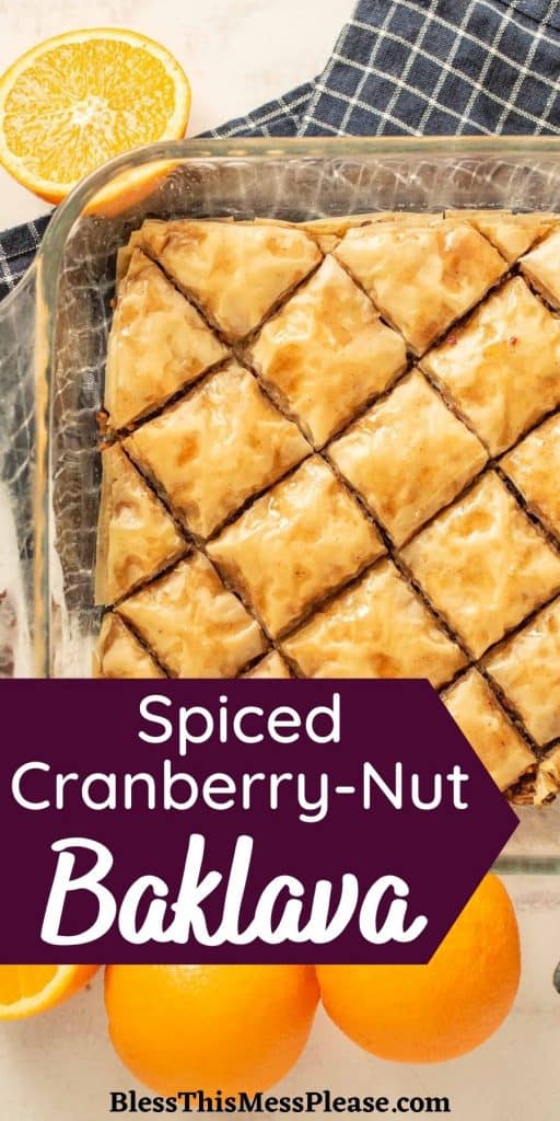 baking pan of baklava next to oranges with the words "spiced cranberry-nut baklava" written at the bottom